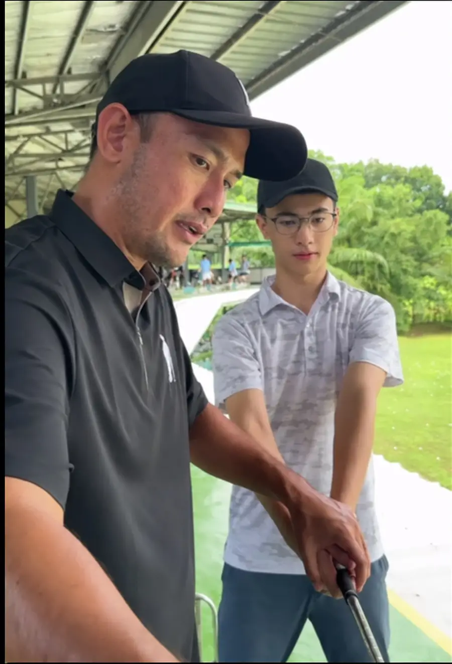 Coach Sammy Sy coaching a junior golfer at the Rapsodo bays